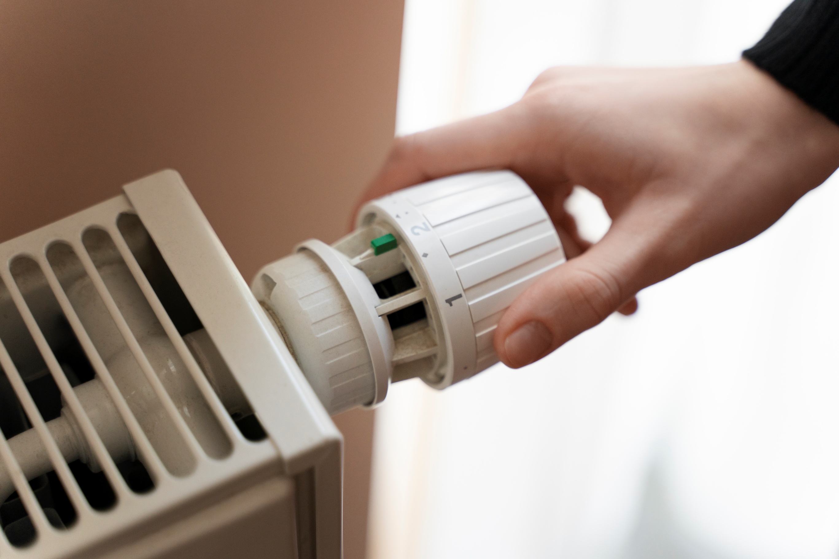 close up hand turning up heater